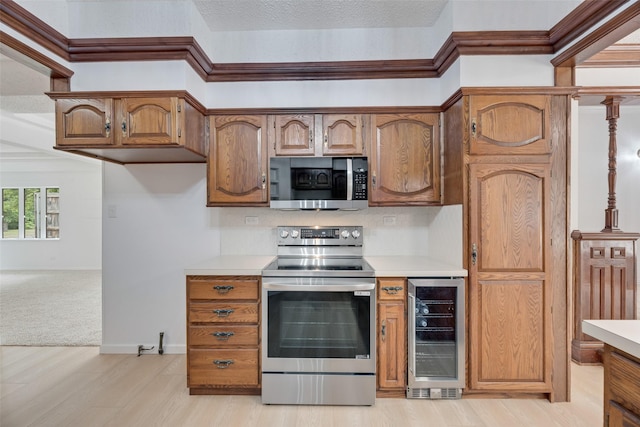 kitchen featuring light countertops, beverage cooler, and appliances with stainless steel finishes