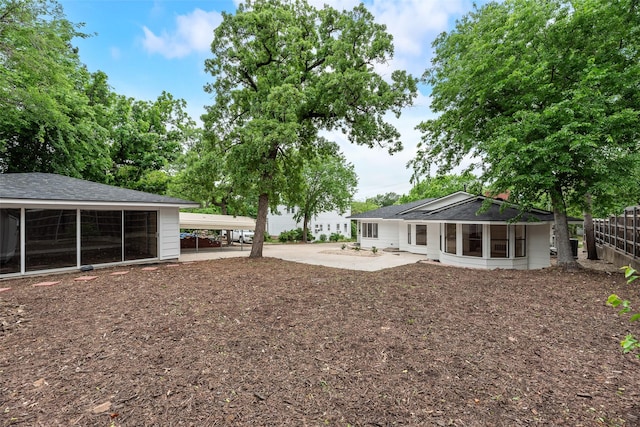 view of yard with a sunroom and fence