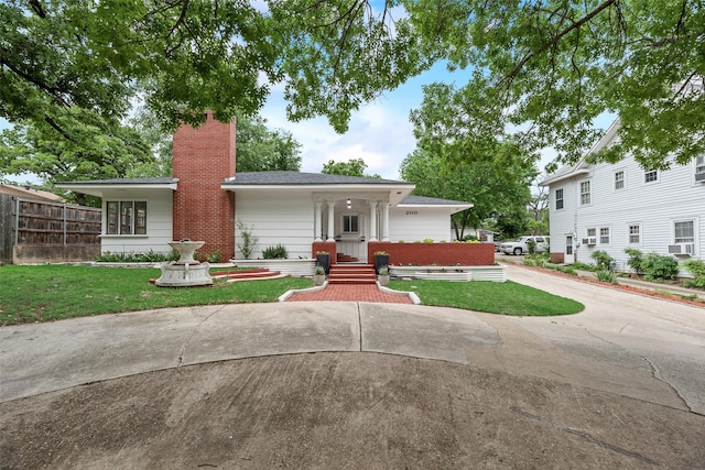 view of front facade featuring a front lawn, fence, and a chimney