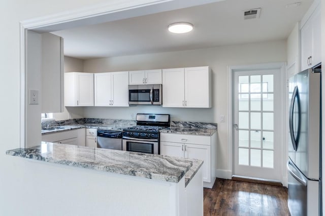 kitchen featuring white cabinets, light stone countertops, stainless steel appliances, dark wood-type flooring, and visible vents