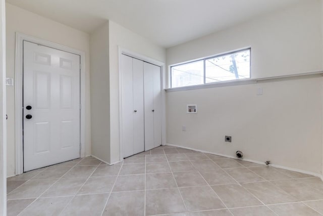 laundry area with laundry area, baseboards, hookup for a washing machine, electric dryer hookup, and light tile patterned floors