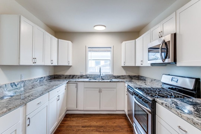 kitchen with a sink, white cabinetry, and stainless steel appliances
