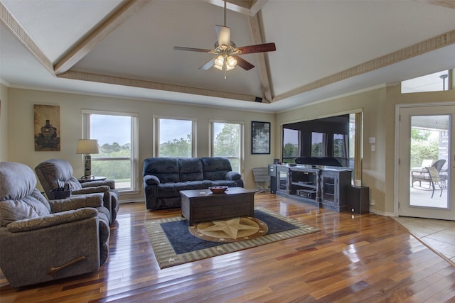 living area with ceiling fan, wood finished floors, a wealth of natural light, and beam ceiling