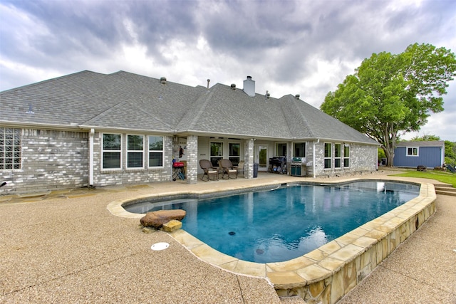 outdoor pool with area for grilling and a patio