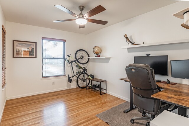 office space featuring baseboards, ceiling fan, and wood finished floors
