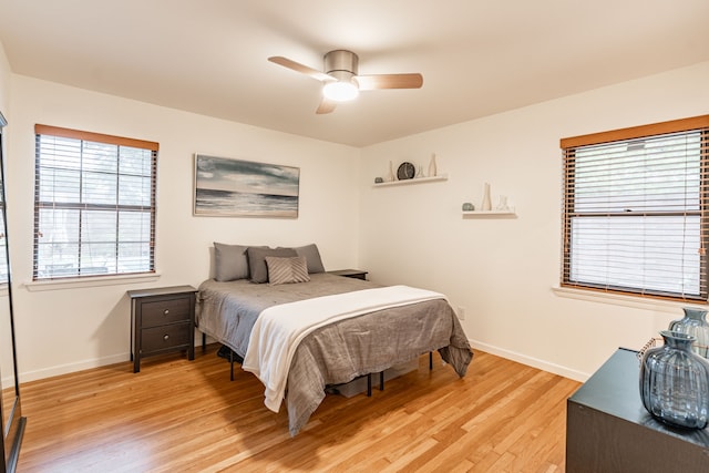bedroom with baseboards, ceiling fan, and light wood-style floors