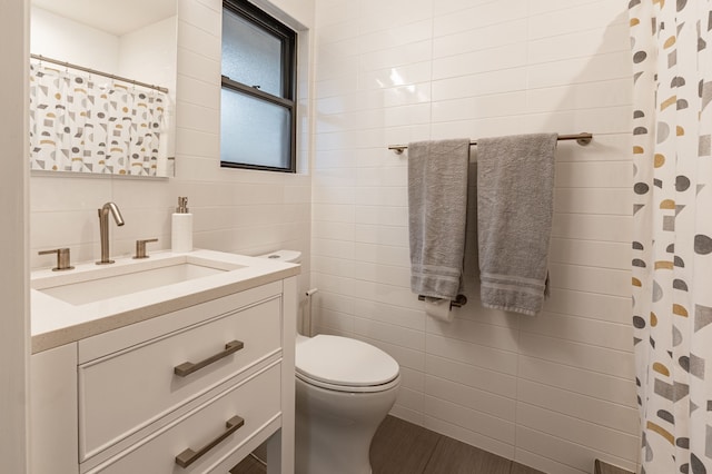 bathroom featuring toilet, tile walls, curtained shower, and vanity