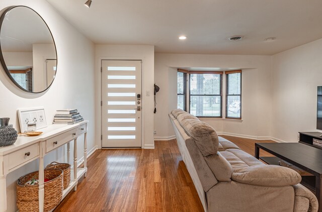 living area with baseboards, recessed lighting, wood finished floors, and visible vents