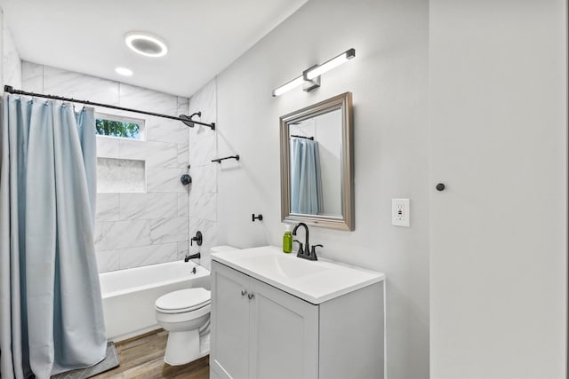 bathroom with toilet, wood finished floors, shower / bath combo, and vanity