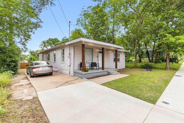view of front of home with a porch, fence, driveway, and a front yard