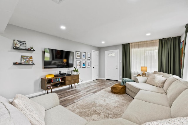 living area with recessed lighting, baseboards, and wood finished floors