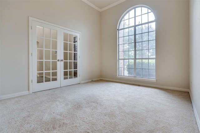 carpeted empty room featuring crown molding, baseboards, french doors, and a wealth of natural light
