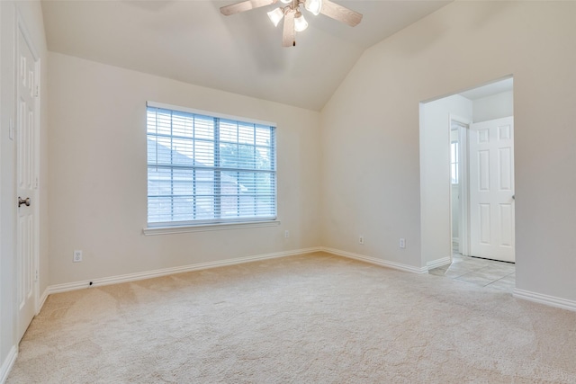 empty room featuring baseboards, light carpet, a ceiling fan, and lofted ceiling