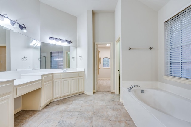 full bath featuring vanity, tile patterned floors, a bath, and a wealth of natural light