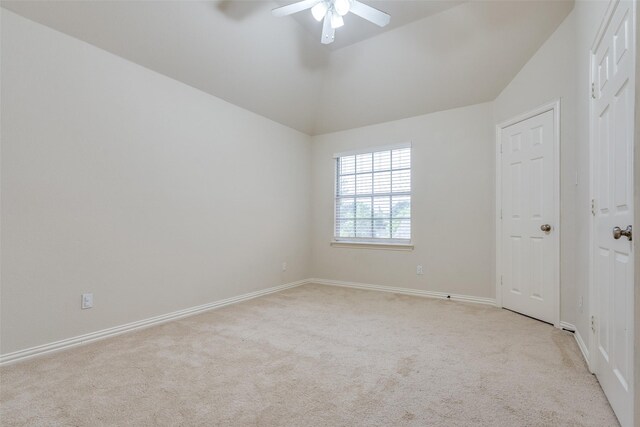 unfurnished room featuring a ceiling fan, baseboards, vaulted ceiling, and light carpet