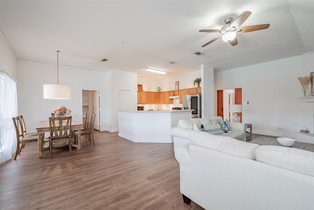 living area with light wood-style floors, baseboards, a ceiling fan, and visible vents