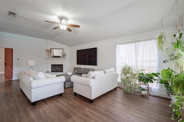 living area with a ceiling fan, visible vents, dark wood-style floors, lofted ceiling, and a glass covered fireplace