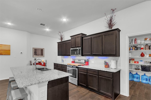 kitchen with a sink, stainless steel appliances, dark wood finished floors, and visible vents