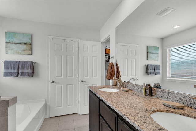 full bath featuring tile patterned flooring, visible vents, double vanity, a bath, and a sink