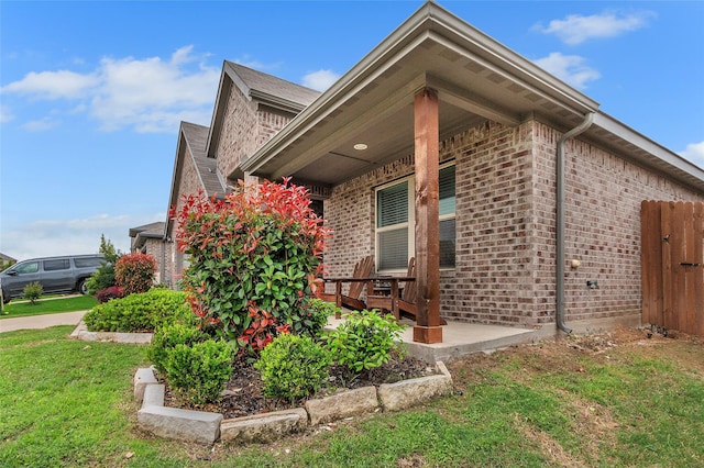 view of side of property featuring brick siding and a lawn