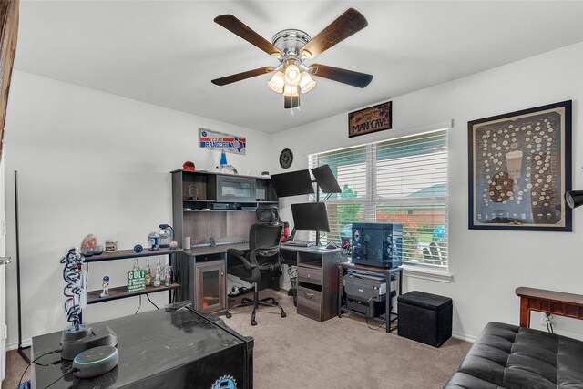 carpeted office featuring baseboards and a ceiling fan