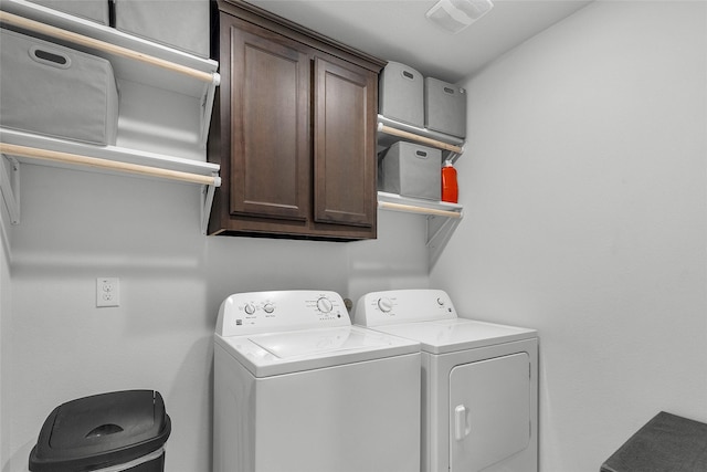 laundry room featuring washing machine and dryer, cabinet space, and visible vents