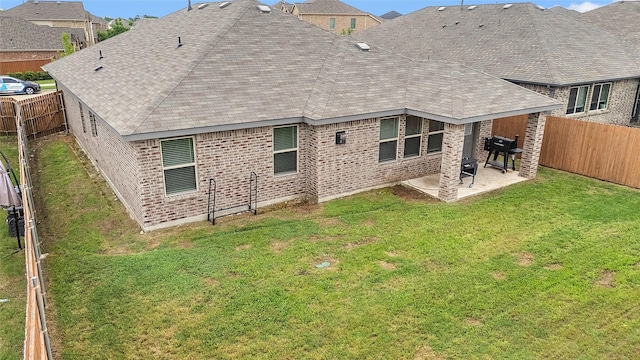 rear view of house featuring a fenced backyard, a patio, and brick siding