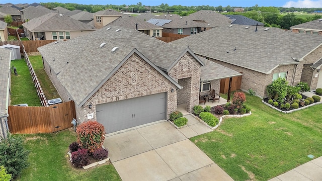 view of front of property with a residential view, a shingled roof, brick siding, a garage, and driveway