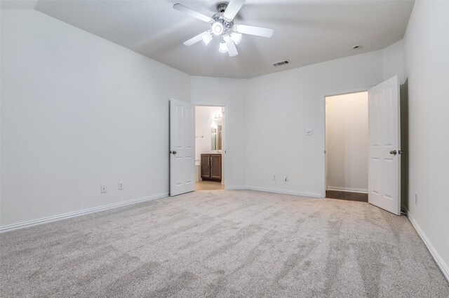 unfurnished bedroom featuring connected bathroom, baseboards, light colored carpet, and visible vents