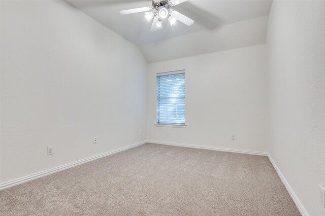 carpeted empty room featuring baseboards, a ceiling fan, and vaulted ceiling