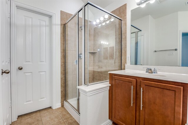 full bath featuring vanity, tile patterned flooring, and a stall shower