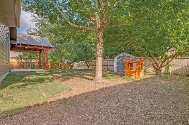 view of yard featuring an outdoor structure, a shed, and a fenced backyard