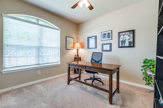 carpeted office featuring ceiling fan and baseboards