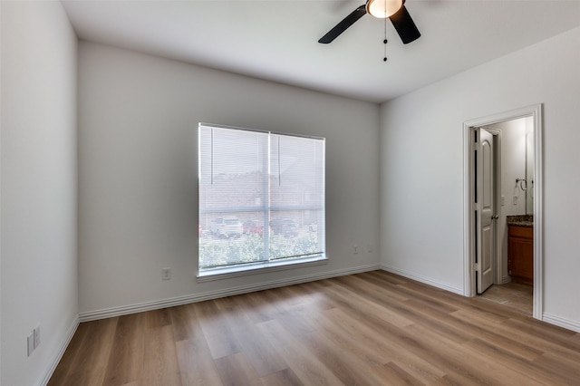2372 Homewood Ln, Grand Prairie, TX 75050 - unfurnished bedroom with light wood-style flooring, baseboards, ensuite bathroom, and ceiling fan