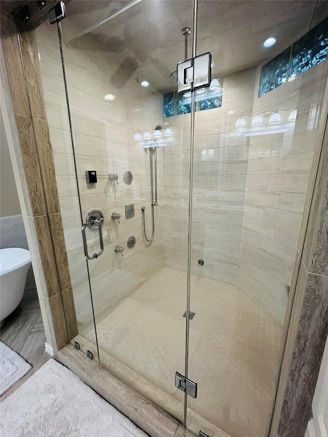 bathroom with a shower stall and a freestanding tub