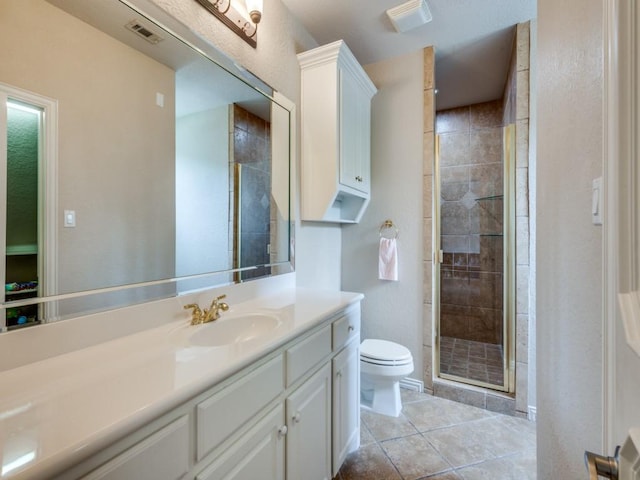 full bath with toilet, a stall shower, vanity, and tile patterned floors