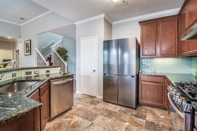kitchen featuring backsplash, visible vents, ornamental molding, stainless steel appliances, and wall chimney exhaust hood