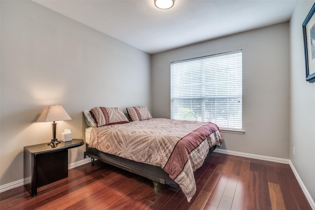 bedroom with baseboards and wood finished floors