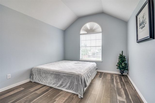 bedroom featuring baseboards, lofted ceiling, and wood finished floors