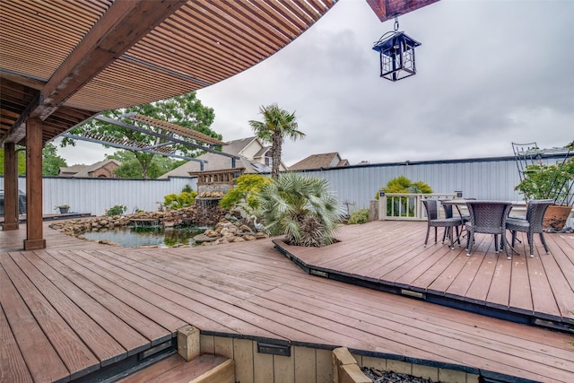 wooden terrace with outdoor dining area and fence