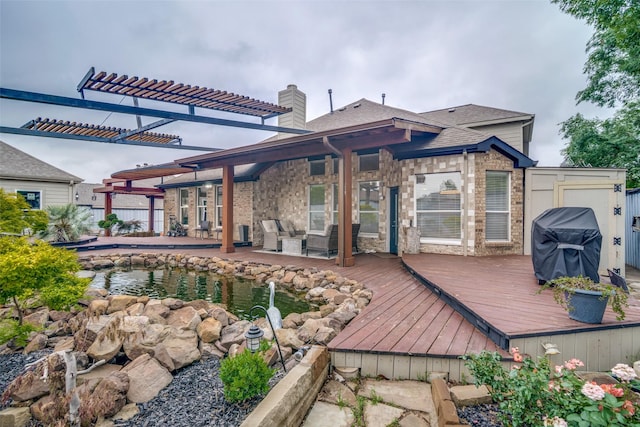 back of property with a shingled roof, a chimney, and a deck
