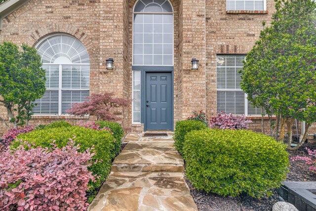 view of exterior entry with brick siding