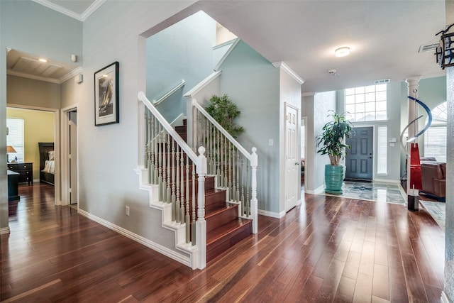 entrance foyer featuring baseboards, ornamental molding, stairs, and dark wood-style floors