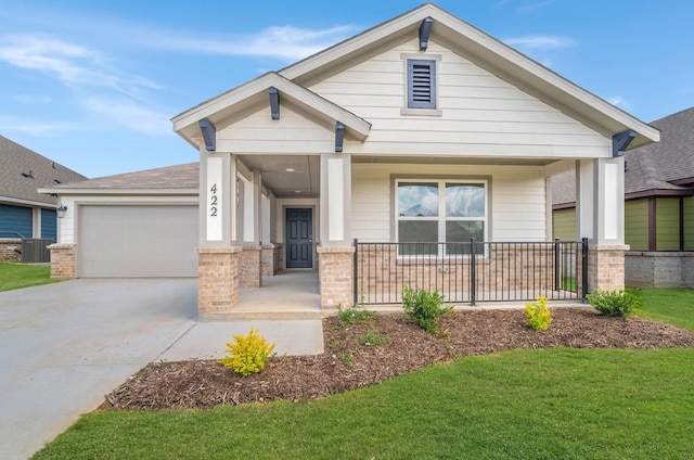 craftsman inspired home featuring covered porch, a front yard, central AC unit, concrete driveway, and an attached garage