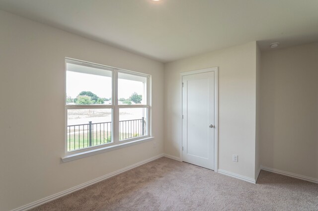 unfurnished room featuring baseboards and carpet