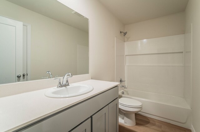 full bath with vanity, toilet, wood finished floors, and shower / tub combination