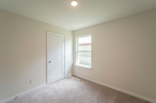 spare room featuring carpet floors and baseboards