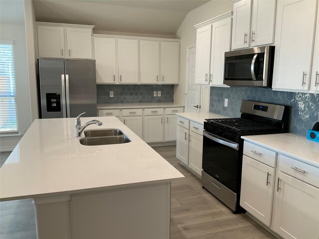 kitchen featuring stainless steel appliances, a wealth of natural light, a sink, and lofted ceiling