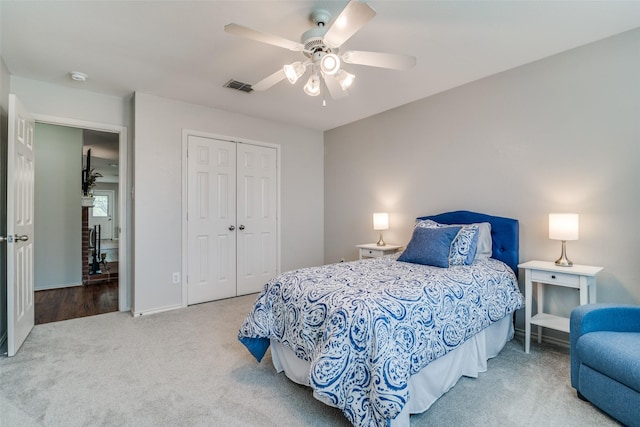 carpeted bedroom featuring ceiling fan, visible vents, baseboards, and a closet