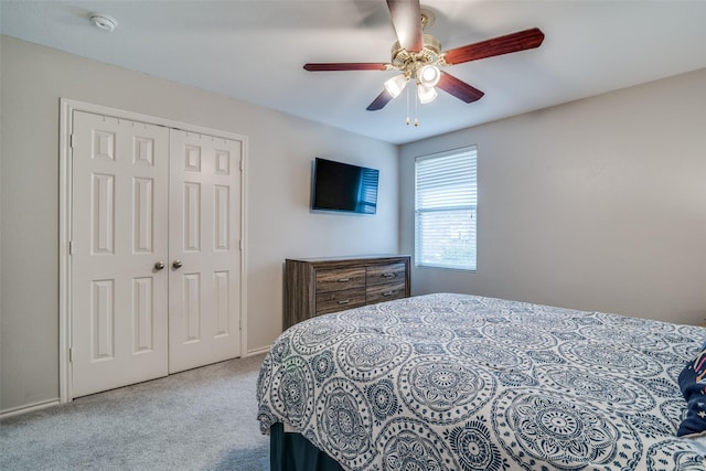 carpeted bedroom with ceiling fan and a closet